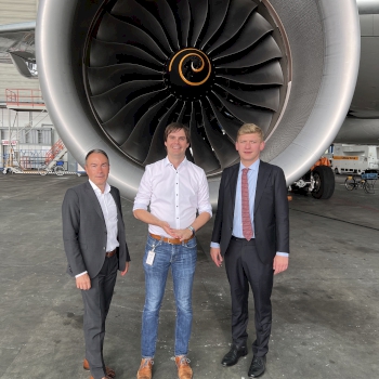 Andreas Mehltretter mit den Gesprächspartnern der Lufthansa vor Triebwerk