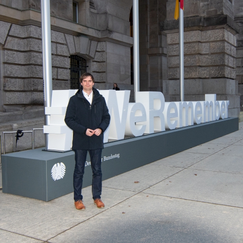 Andreas Mehltretter vor dem #WeRemember-Schriftzug am Reichstagsgebäude