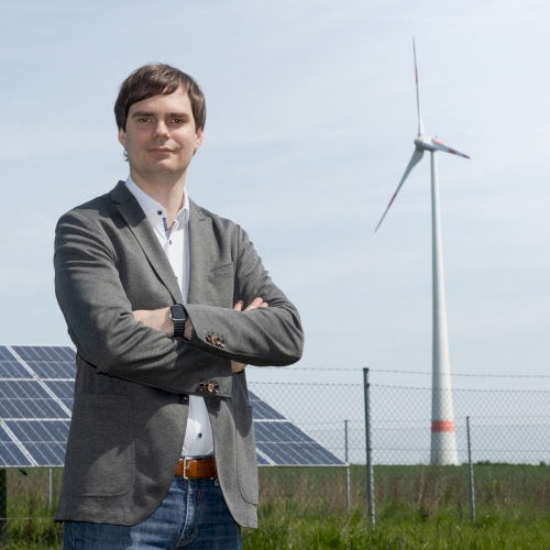 Andreas Mehltretter vor PV-Anlage und Windrad