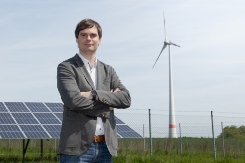 Andreas Mehltretter vor PV-Anlage und Windrad